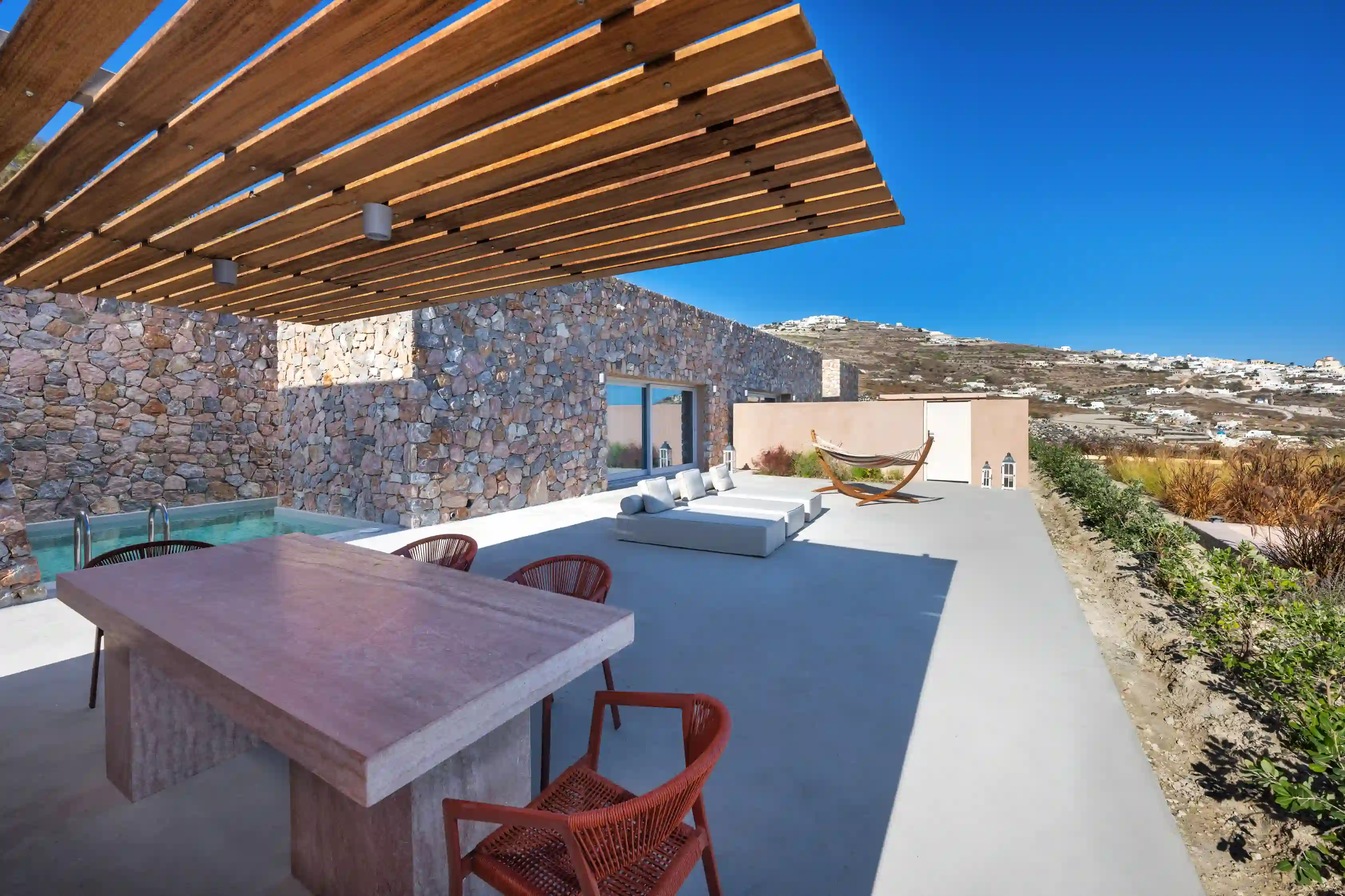 Deluxe Gaia Cave Villa relaxation patio - Private pool with sun loungers and Santorini landscape views