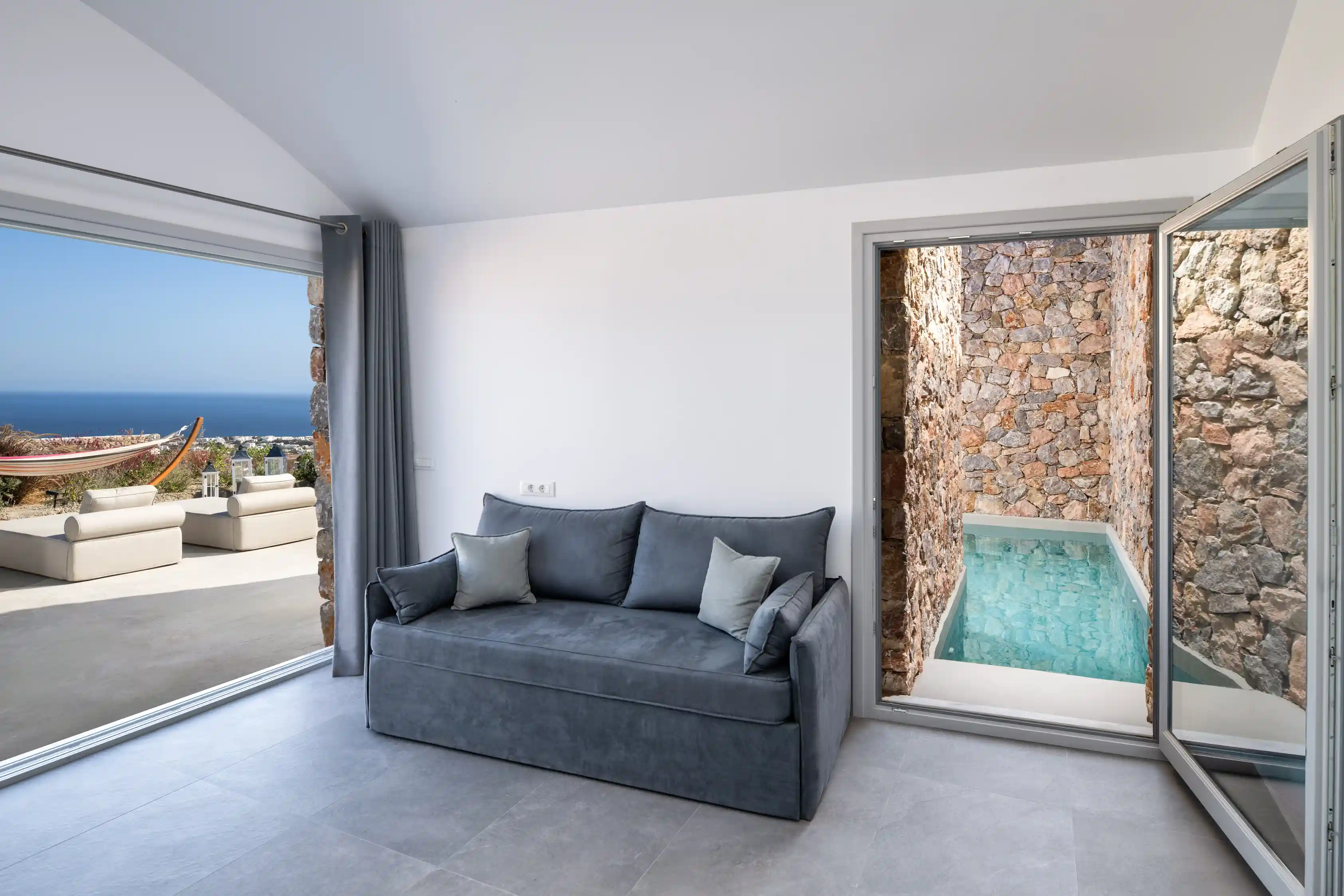 Deluxe Gaia Cave Villa living room with pool view - Modern interior design with direct pool access