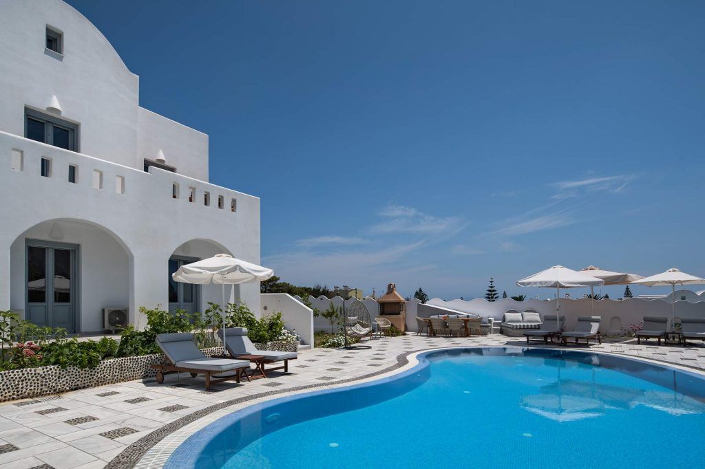 Evening ambiance at Felicity Villas Santorini with illuminated pool and mountain backdrop